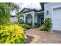 Inviting front entrance with brick pathway and meticulously maintained, colorful landscaping at 5597 Bay Tide Ct, Land O Lakes, FL 34638