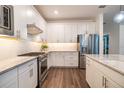 Modern kitchen features white cabinetry, stainless steel appliances, and granite countertops at 5597 Bay Tide Ct, Land O Lakes, FL 34638