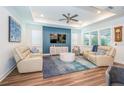 Bright living room boasts elegant tray ceilings, stylish furnishings, and a modern accent wall at 5597 Bay Tide Ct, Land O Lakes, FL 34638