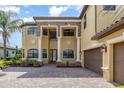 Elegant two-story home with impressive columns, a brick driveway and an attached two-car garage at 5656 Cloverleaf Run, Bradenton, FL 34211