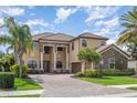 Stately two-story home with lush landscaping, brick driveway, and grand entrance with impressive columns at 5656 Cloverleaf Run, Bradenton, FL 34211