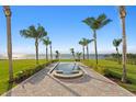 Lush backyard with a tranquil reflecting pool leading to breathtaking water views, framed by swaying palm trees at 6106 Marbella Blvd, Apollo Beach, FL 33572