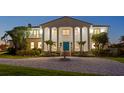Elegant home facade featuring a circular driveway, water fountain, and well-manicured landscaping at 6106 Marbella Blvd, Apollo Beach, FL 33572