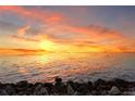 Picturesque waterfront view at sunset with gentle waves lapping the rocky shoreline at 6106 Marbella Blvd, Apollo Beach, FL 33572