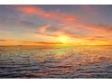 Stunning sunset over the ocean with a distant cityscape and vibrant colors in the sky at 6106 Marbella Blvd, Apollo Beach, FL 33572