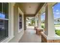 Inviting covered front porch with decorative stone pillars and neutral tones, perfect for relaxing outdoors at 6642 Current Dr, Apollo Beach, FL 33572