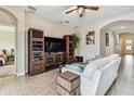 Cozy living room features neutral colors, tiled floors, built-in shelves, and archway into entry at 6642 Current Dr, Apollo Beach, FL 33572
