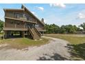 Gorgeous raised two-story home featuring wooden decks and staircase on spacious lot with driveway at 7606 Four Pines Rd, Plant City, FL 33565