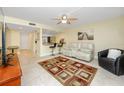 Inviting living room features tile floors, a ceiling fan, and a view of the kitchen with bar seating at 7645 Sun Island S Dr # 304, South Pasadena, FL 33707