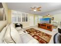 Bright living room showcasing plantation shutters, a ceiling fan, and a mirrored wall for an open feel at 7645 Sun Island S Dr # 304, South Pasadena, FL 33707