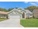 Charming home with well-maintained lawn, landscaping, and a two-car garage at 9375 French Quarters Cir, Weeki Wachee, FL 34613