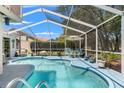 Screened-in pool area with chairs and table provides a relaxing outdoor oasis at 9375 French Quarters Cir, Weeki Wachee, FL 34613