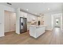 Bright, all-white kitchen featuring stainless steel appliances and a large island at 9408 Coastline Way, Parrish, FL 34219