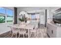 Inviting dining area showcases a large window, modern lighting and stylish furnishings with wood-look flooring at 9482 Shorebird Ct, Parrish, FL 34219