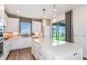Modern kitchen boasts a spacious island with white cabinets, stainless appliances and a sliding glass door at 9482 Shorebird Ct, Parrish, FL 34219