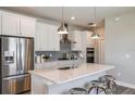 Bright kitchen with white cabinets, stainless steel appliances, and a large island with seating at 9526 Coastline Way, Parrish, FL 34219