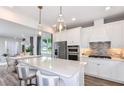 Modern kitchen featuring stainless steel appliances, a central island, and pendant lighting at 9530 Coastline Way, Parrish, FL 34219