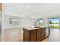 Open-concept kitchen island with stainless steel appliances, views of the living area and backyard lake at 10317 Cross River Trl, Parrish, FL 34219