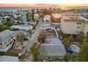 Neighborhood street with single-Gathering homes and palm trees near a sunset beach at 150 95Th Ave, Treasure Island, FL 33706