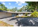 Attractive single-story home showcasing a large front yard, attached garage, and lush landscaping at 18906 Crescent Rd, Odessa, FL 33556