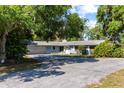Inviting single-story home with an attached garage, well-maintained lawn, and shady trees at 18906 Crescent Rd, Odessa, FL 33556