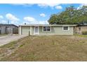 Inviting one-story home featuring a well-kept lawn and neutral-colored exterior on a sunny day at 2166 Dixie Garden Loop, Holiday, FL 34690