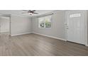 Bright living room with sleek floors, a modern ceiling fan, and a sunlit window at 2166 Dixie Garden Loop, Holiday, FL 34690