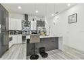 Open kitchen features sleek cabinetry, stainless appliances, and a spacious island with bar seating at 2305 W Kentucky Ave, Tampa, FL 33607