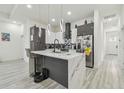 Modern kitchen boasts sleek gray and white cabinetry, marble countertops, and pendant lighting at 2305 W Kentucky Ave, Tampa, FL 33607