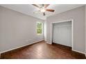 Cozy bedroom featuring wood floors, a ceiling fan, and a closet for ample storage at 2512 Clubhouse Dr, Plant City, FL 33566
