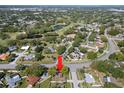 Aerial view of a home nestled in a lush neighborhood near a golf course with mature trees and a pond at 2961 Stockwood Dr, Clearwater, FL 33761