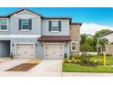 Delightful townhome with a two-car garage, charming curb appeal, and stone accents at 30752 Veridian Way, Wesley Chapel, FL 33545