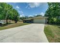 Exterior of home with a large driveway, lush lawn, and a 2 car garage at 3206 Shalimar Ter, North Port, FL 34286