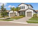 Charming two-story home with a three-car garage, brick driveway, and well-manicured landscaping at 4365 Frontera Ln, Wesley Chapel, FL 33543
