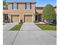 Inviting exterior of a two-story townhome with individual garage and private driveways at 4535 Winding River Way, Land O Lakes, FL 34639