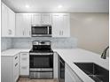 Modern kitchen with white cabinets, stainless steel appliances, and stylish backsplash at 4535 Winding River Way, Land O Lakes, FL 34639