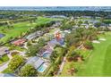 Panoramic aerial view showcases the property's location on a lush golf course with a glimpse of the bay at 634 Poinsettia Rd, Belleair, FL 33756