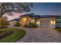 Stunning home exterior with elegant design, three-car garage, and brick driveway at 634 Poinsettia Rd, Belleair, FL 33756