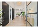Inviting foyer with elegant light fixture, hardwood floors, and open floor plan at 634 Poinsettia Rd, Belleair, FL 33756