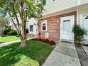 Close up on front of townhome with a beautiful flower bed in front of the red brick front at 7508 Hollowell Dr, Tampa, FL 33615