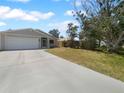 Inviting single-story home featuring a spacious driveway and a well-maintained lawn with mature trees at 804 Pineland Ave, Venice, FL 34285