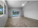 Bright living room with tile flooring and a sliding glass door with a view to the backyard pool at 804 Pineland Ave, Venice, FL 34285