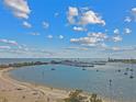 Scenic aerial view of a marina with sailboats and yachts, set against a backdrop of blue sky and fluffy clouds at 90 Martinique Ave, Tampa, FL 33606