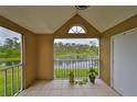Screened balcony showcasing a serene view of the lake and surrounding greenery at 9481 Highland Oak Dr # 1206, Tampa, FL 33647
