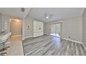 Bright living room with modern flooring, ceiling fan, and sliding glass doors to the balcony at 9481 Highland Oak Dr # 1206, Tampa, FL 33647