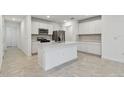 Bright kitchen with white cabinets, stainless steel appliances, and a large island at 10418 Cross River Trl, Parrish, FL 34219