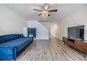 Open-concept living room with wood floors, stairway, and a comfortable blue couch at 10906 Keys Gate Dr, Riverview, FL 33579