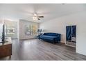 Bright living room featuring wood floors, fan, and large windows allowing natural light at 10906 Keys Gate Dr, Riverview, FL 33579
