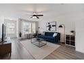 Bright living room featuring a blue sofa, modern decor, and a dedicated workspace by the window at 10906 Keys Gate Dr, Riverview, FL 33579