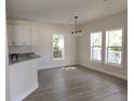 Bright dining room with modern chandelier, wood-look flooring and large windows overlooking the outdoors at 1537 Palmetto St, Clearwater, FL 33755